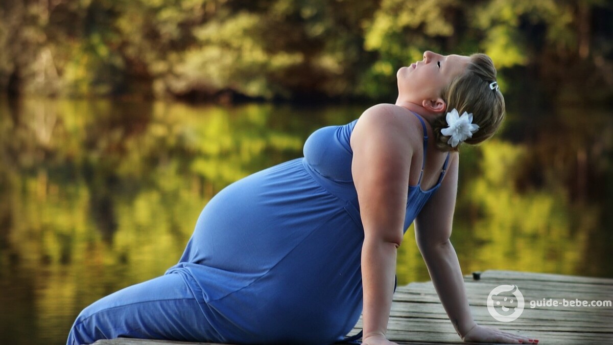 Femme enceinte sur un ponton au bord d'un lac